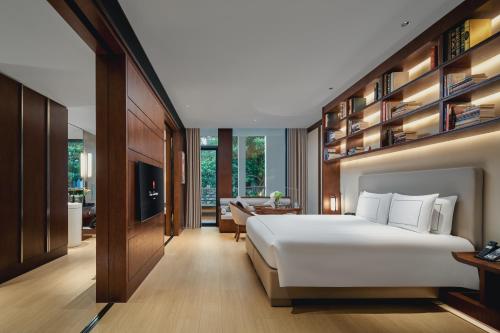 a bedroom with a large white bed and a living room at Tonino Lamborghini Hotel Suzhou in Suzhou