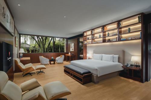 a bedroom with a bed and a living room at Tonino Lamborghini Hotel Suzhou in Suzhou