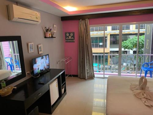 a living room with a television and a large window at New Lavender Hotel Patong in Patong Beach