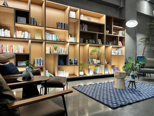 a library with bookshelves and a table and chairs at Adagio Dapeng Bay in Donggang