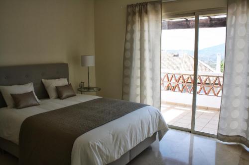 1 dormitorio con 1 cama y balcón con vistas. en La Cala Golf Townhouse, en La Cala de Mijas