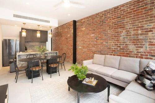 a living room with a couch and a brick wall at Richmond Sanctuary in Melbourne