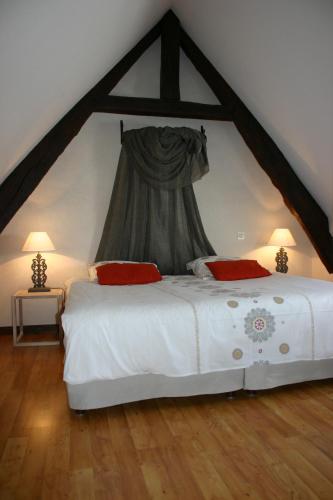 a bedroom with a large white bed in a attic at Ferme Saint Christophe in Saint-Marcan