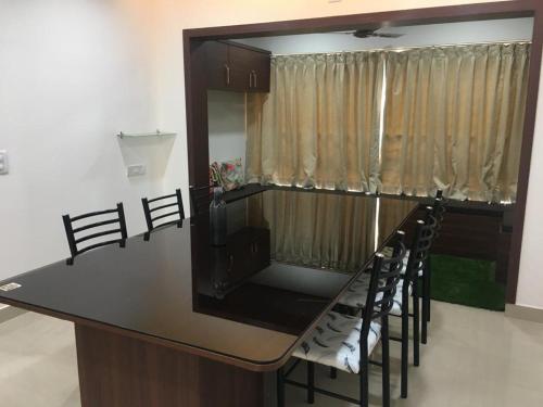 a kitchen with a counter with a bar with chairs at Vaishnavi furnished flats in Mangalore