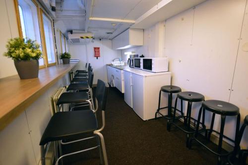 a room with a row of stools and a counter and a kitchen at Hotellilaiva Muikku/Hotel Boat Muikku in Helsinki