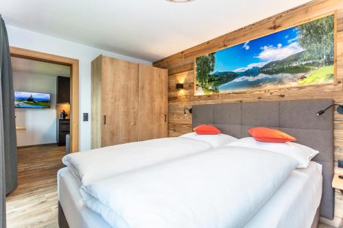 two white beds in a room with wooden walls at Erlbruckhof in Zell am See