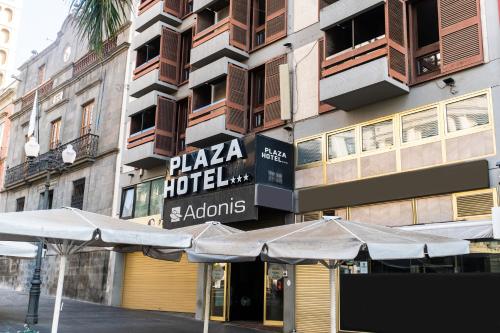 un hotel con sombrillas frente a un edificio en Hotel Adonis Plaza en Santa Cruz de Tenerife