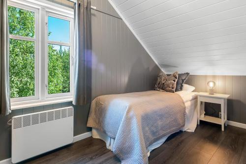 1 dormitorio con 1 cama y 2 ventanas en Villa Heidi, en Ulven