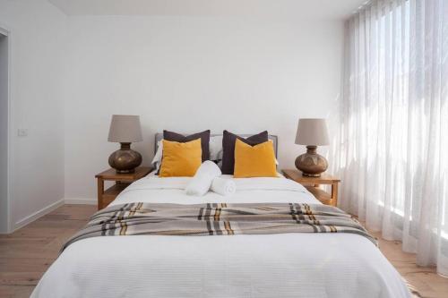 a bedroom with a large bed with yellow pillows at Richmond Sanctuary in Melbourne