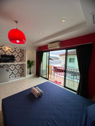 a bedroom with a blue bed and a large window at Petunya Phuket Guest House in Ban Huai Luk (1)