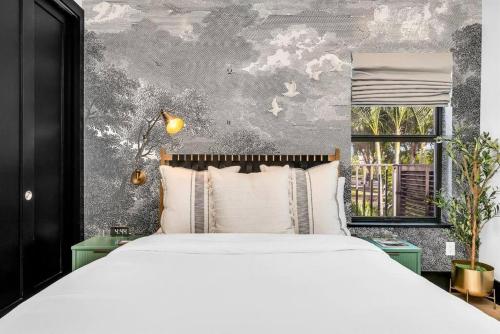 Un dormitorio con una gran cama blanca y una ventana. en Flamingo Park Paradise: Luxury Poolside Haven, en West Palm Beach