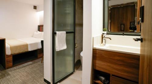 a bathroom with a sink and a bathroom with a bed at ST Signature Bugis Middle, SHORT OVERNIGHT, 11 hours 8PM-7AM in Singapore