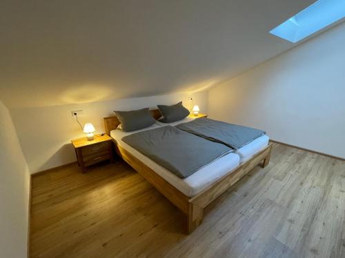 ein Schlafzimmer mit einem Bett und zwei Nachttischen mit Lampen in der Unterkunft Liebling's Platzl in Eberfing