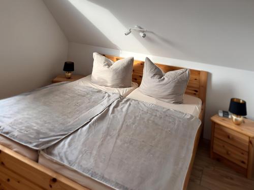 a bedroom with a bed with white sheets and pillows at Ferienhaus am Saaler Bodden in Beiershagen