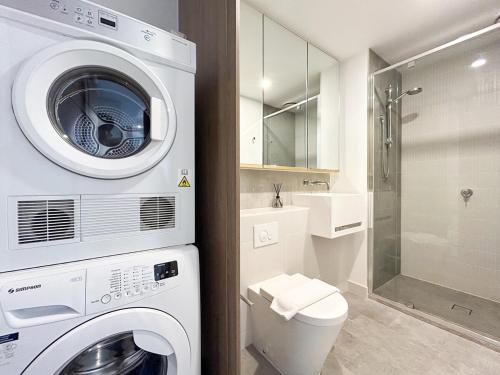 uma máquina de lavar e secar roupa branca na casa de banho em Inner City 1br1ba In Cbd Pool Gym Wi-fi em Melbourne