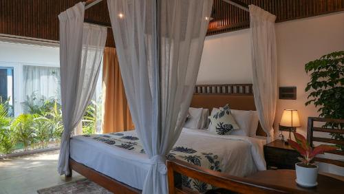 a bedroom with a bed with a canopy at Swimup - Suites with private pool , Vagator in Vagator