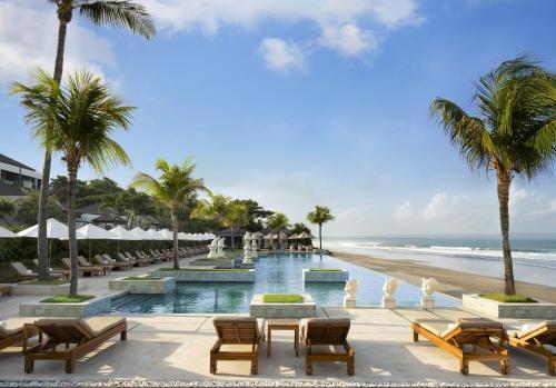 a resort with a pool and a beach with palm trees at The Seminyak Beach Resort & Spa in Seminyak