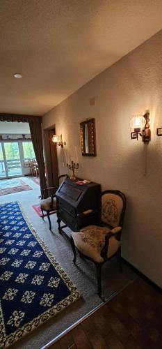 sala de estar con piano y silla en Waldrand Haus B 4. Stock, en Bellwald