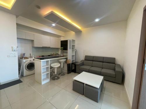 uma pequena sala de estar com um sofá e uma cozinha em Comfy Stay by SE em Johor Bahru
