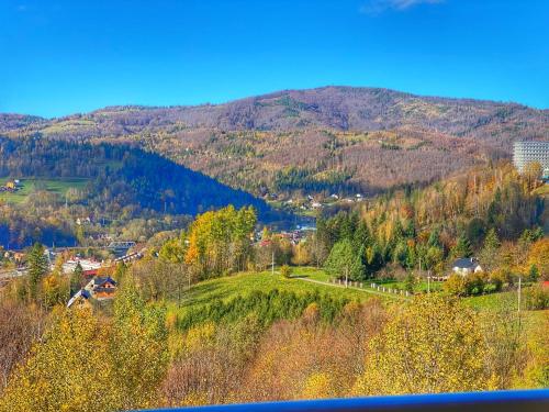 a town on a hill with mountains in the background at Apartamenty Szóstka Wisła Kamienna in Wisła