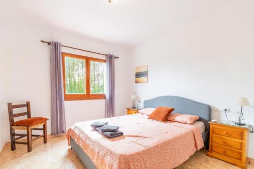 a bedroom with a bed and a chair and a window at La Boniquesa in Benissa