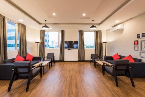 ein Wohnzimmer mit Sofas, Tischen und Fenstern in der Unterkunft Townhouse MG Road,Bangalore in Bangalore