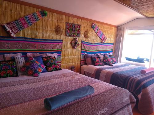 a bedroom with two beds and a window at TITICACA DELUXE LODGE in Puno