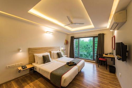 a hotel room with a bed and a television at Super Townhouse MG Road,Bangalore in Bengaluru