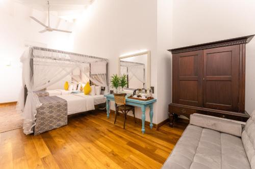 a bedroom with a bed and a table with a desk at The Fort House in Galle