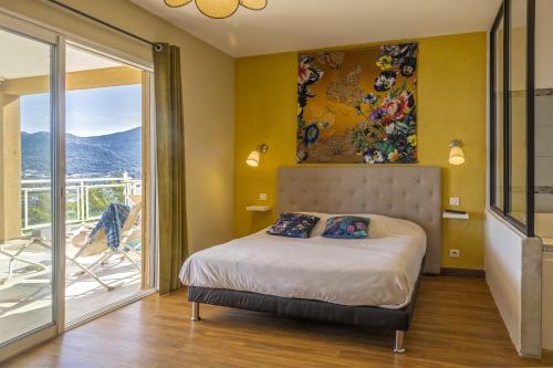 ein Schlafzimmer mit einem Bett und einem Balkon in der Unterkunft Villa Carlisa in Algajola