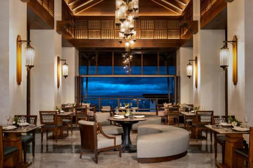 a restaurant with tables and chairs and a large window at Dusit Thani Himalayan Resort Dhulikhel, Nepal in Dhulikhel