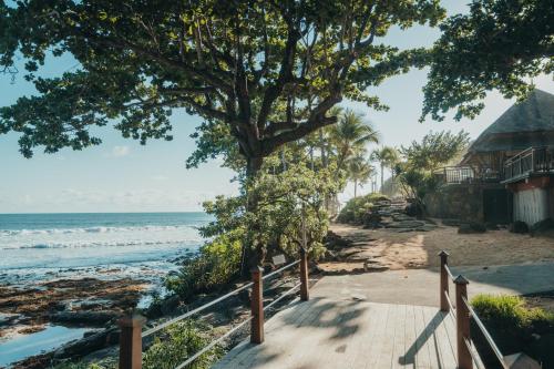a walkway to the beach with a tree and a house at Tamarina Golf & Spa Boutique Hotel in Flic-en-Flac