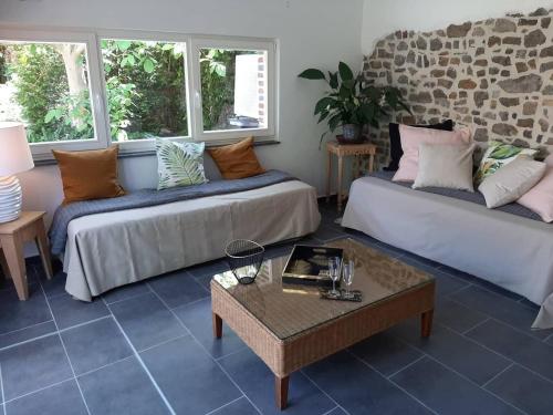 a living room with two couches and a table at Gîte La Columbia Lens en Hainaut in Cambron-Saint-Vincent