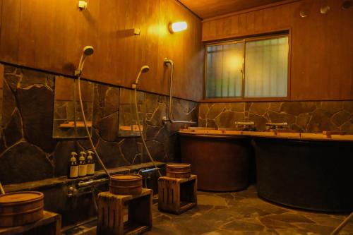 a large bathroom with a tub and a sink at Kaya Yamanoie in Yosano