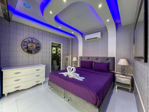 a bedroom with a purple bed with a ribbon on it at VIEW TALAY VILLAs POOL 291, JOMTIEN BEACH, PATTAYA in Jomtien Beach