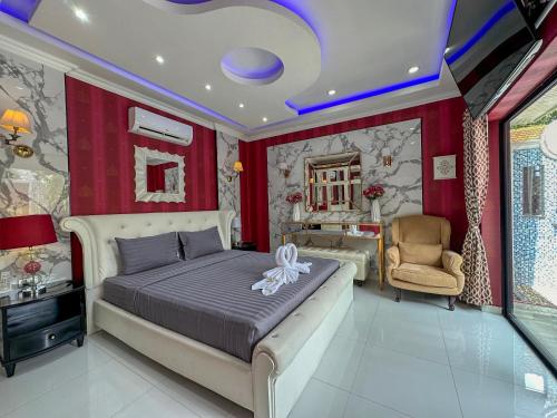 a bedroom with a large bed and a chair at VIEW TALAY VILLAs POOL 291, JOMTIEN BEACH, PATTAYA in Jomtien Beach