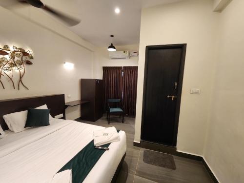 a hotel room with a bed and a black door at Udupi Comforts in Udupi