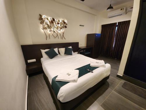 a hotel room with a bed with towels on it at Udupi Comforts in Udupi