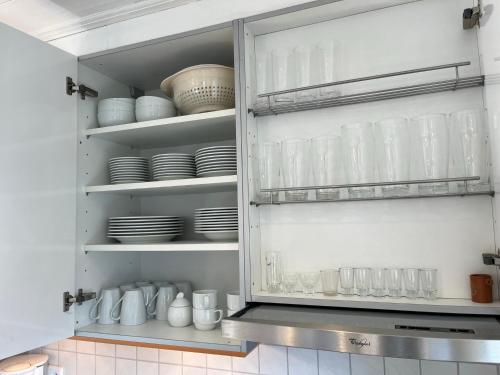 a kitchen cabinet filled with dishes and plates at Ferienwohnung Victoria in Brixen im Thale