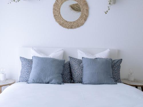 um quarto com uma cama branca com almofadas azuis e um espelho em Chez-Marie Vue fantastique entre lac et montagne em Beckenried