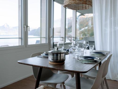 a wooden table with glasses and a pot on it at Chez-Marie Vue fantastique entre lac et montagne in Beckenried