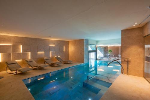 a swimming pool in a house with chairs and tables at Relais & Spa Castello di Casiglio in Erba