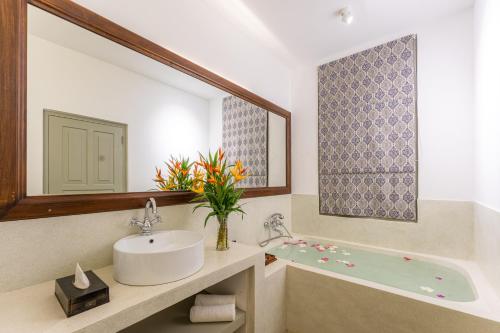a bathroom with a sink and a bath tub at The Fort House in Galle
