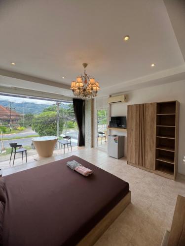a bedroom with a large bed and a large window at Petunya Phuket Guest House in Ban Huai Luk (1)