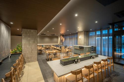 a restaurant with wooden tables and chairs and windows at SAKURA PORT HOTEL in Kitakami