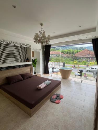 a bedroom with a large bed and a large window at Petunya Room 1 in Ban Huai Luk (1)