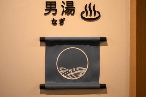 a sign with a mirror and chinese writing on it at SAKURA PORT HOTEL in Kitakami