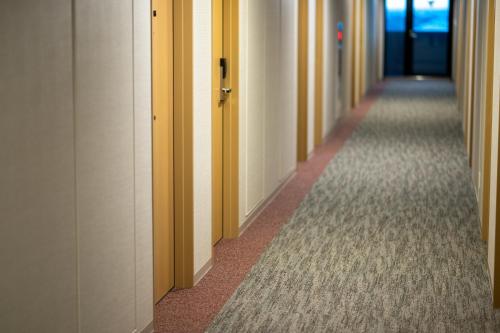 a hallway of an office with yellow and white walls at SAKURA PORT HOTEL in Kitakami