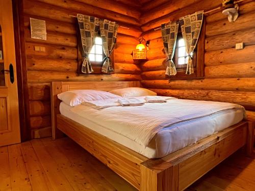 a bedroom with a bed in a log cabin at Ubytovanie Koliba Pacho - Zrub Anicka in Prievidza