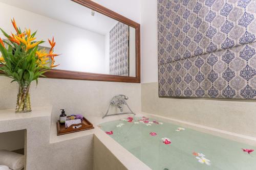 a bathroom with a bath tub with a mirror at The Fort House in Galle